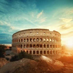 Romes Colosseum with sun behind it.